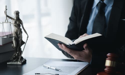 A product liability lawyer going through a law book to prepare for a case.