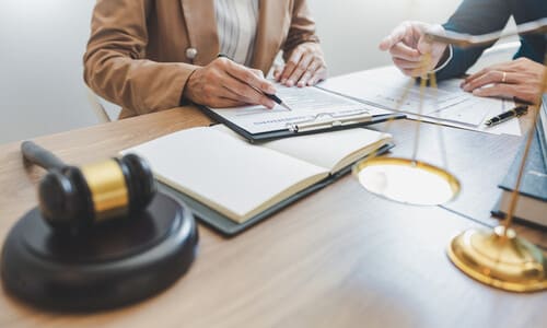 A car accident lawyer in an office explaining distribution of fault to a client.