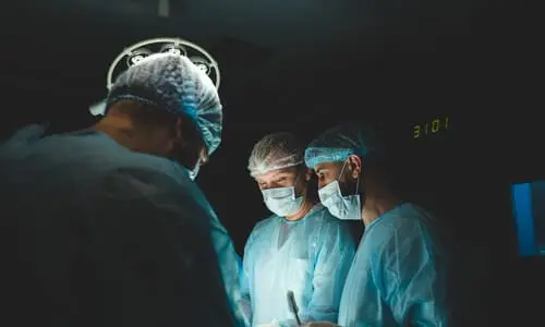 A surgical team in an operating theater working to amputate an accident victim.