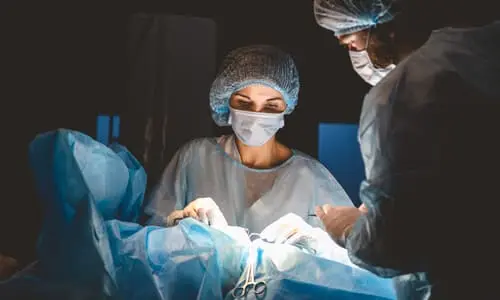 A medical team in an operating theater attempting to repair a birth injury in a newborn.