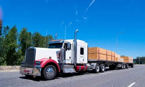 A large semi truck transporting a heavy load of transportation materials.