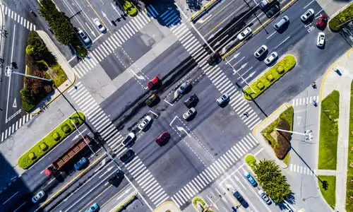 An aerial view of heavy traffic going through an intersection at daytime.