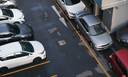 An aerial shot of a parking lot with multiple cars lined up and trying to enter.
