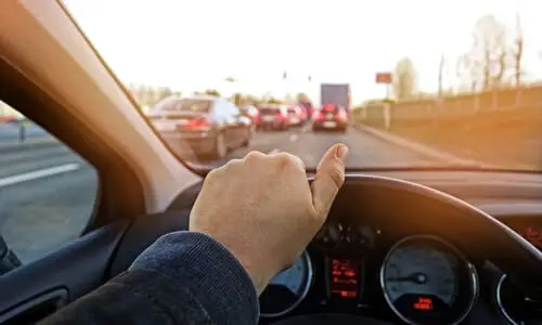 A first person view photo of a man driving his car at speed towards traffic.