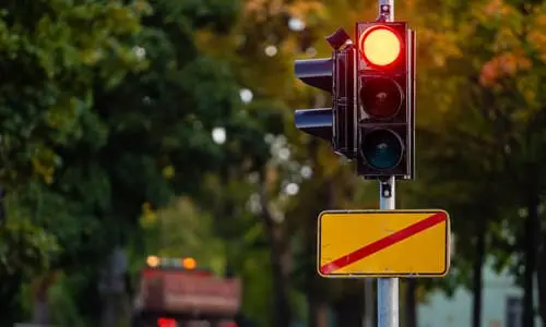 An out of focus shot of a truck having a red light on a suburban road.