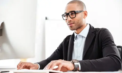 A road rage lawyer working on a laptop and eyeing details of a client's case.