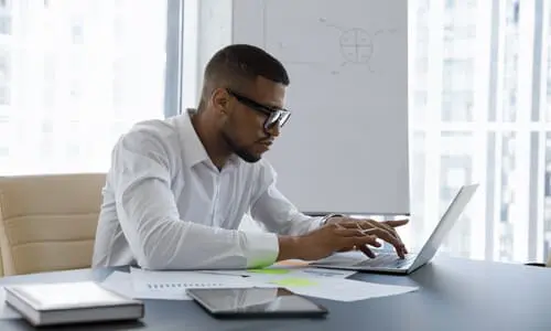 A wrong way accident lawyer working diligently on a case on his laptop.