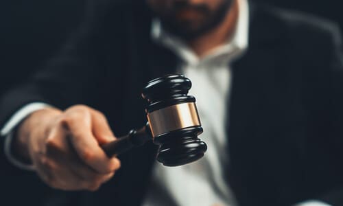 A selective focus shot of a lawyer hovering a gavel over a soundblock.