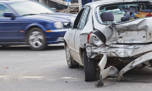 A blue vehicle losing control and about to collide with other vehicles involved in an accident.