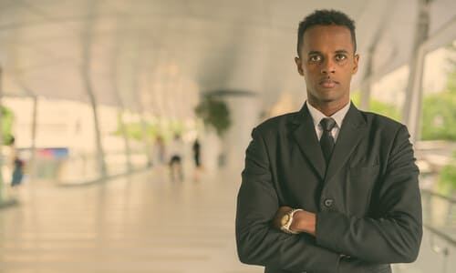 A construction accident lawyer standing cross-armed and staring intently directly ahead.