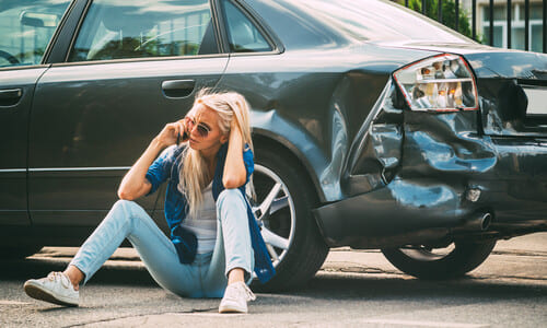 A woman on a phone with her lawyer asking about options after an accident.