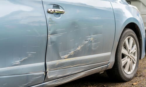 An accident victim's car having taken damage to its doors after another vehicle's bad lane change.