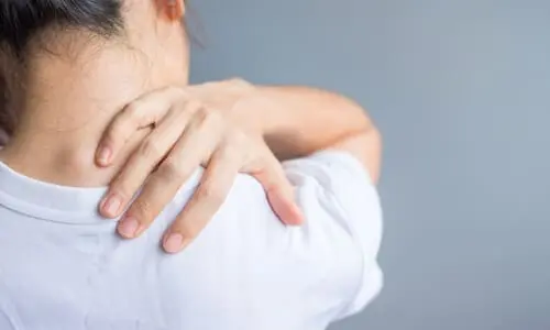 A car accident victim reaching for her back because of pain caused by an injury.