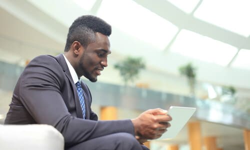 A negligence lawyer in a building lobby communicating with a client over a tablet.