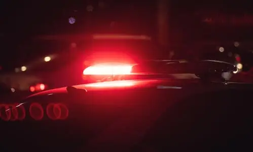 A closeup shot of a police cruiser's red flasher shining at night.