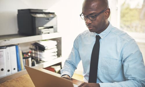 A product liability lawyer in an office building working on a computer to build a case for his client.