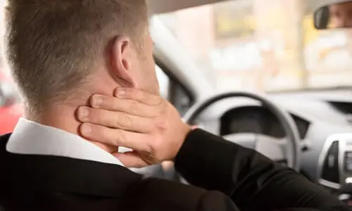 A driver grasping his neck out of pain caused by whiplash.
