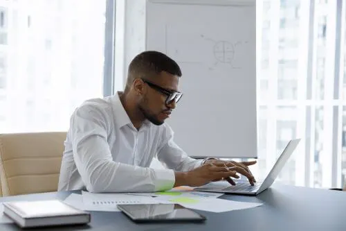 A construction accident lawyer at a desk and signing documents on behalf of a client.