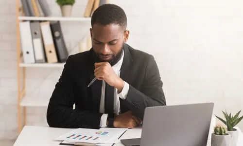 A personal injury attorney holding up a pen and looking at his client's expenses after an accident.