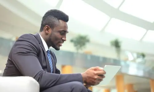 A personal injury lawyer holding up a tablet while communicating with a client.
