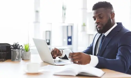 A personal injury lawyer looking at his laptop while working on a case for a client.