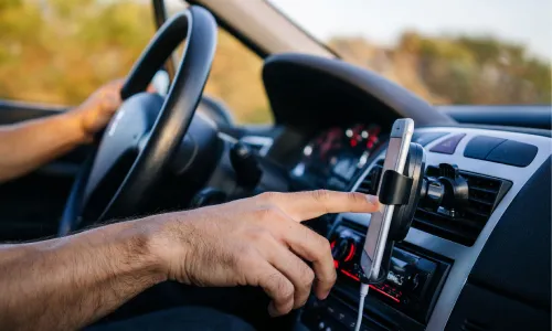 A rideshare driver inputting his next route on a smartphone before driving.